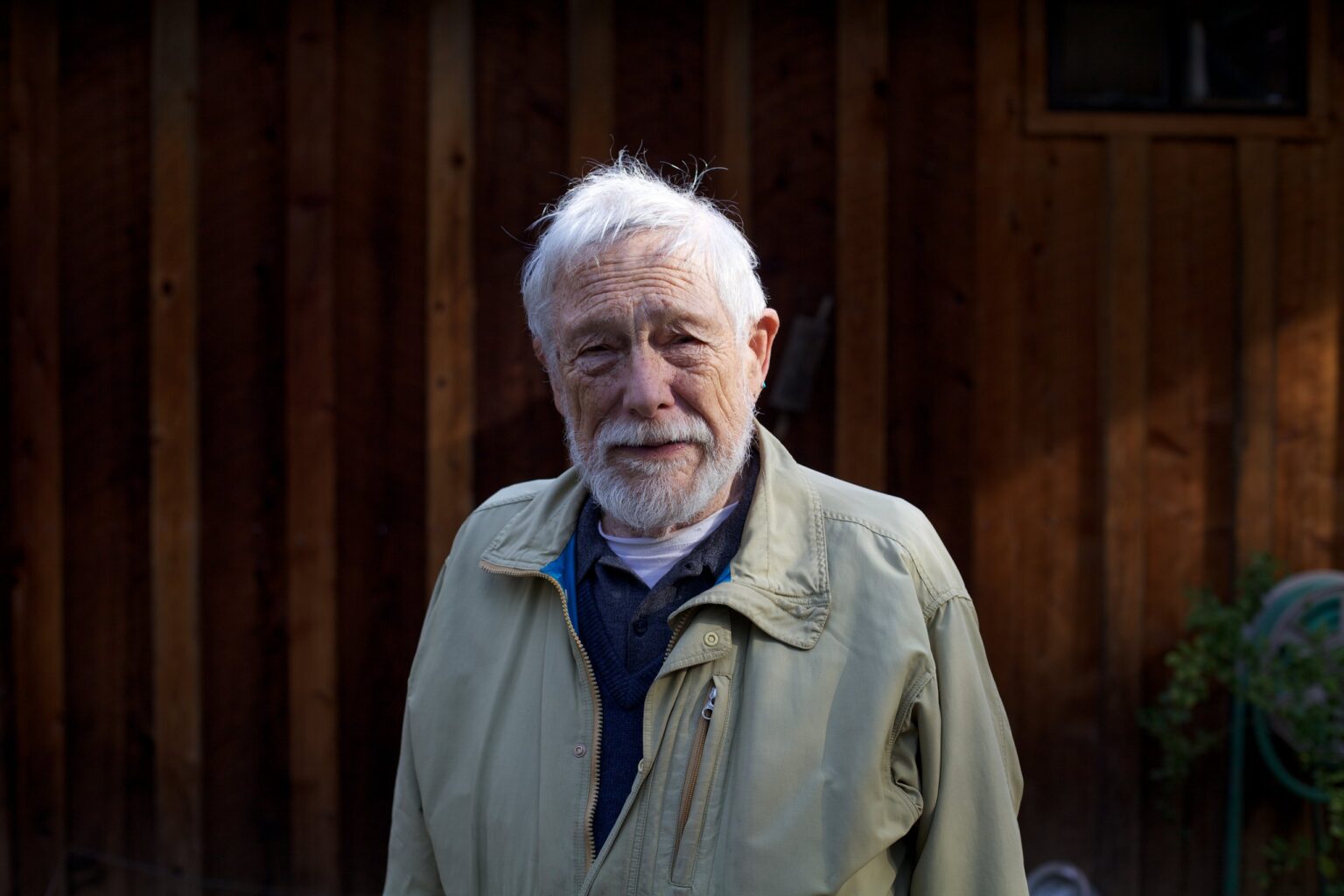 A portrait taken during the journey, beside a wooden facade.