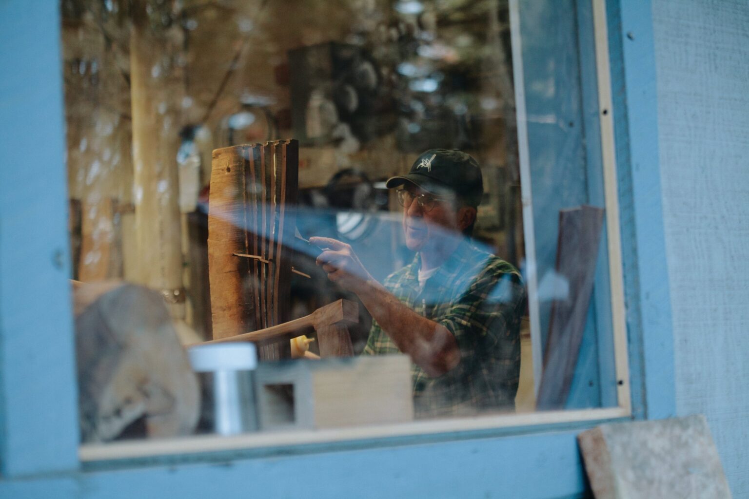 Work inside the workshop seen through a blue window.